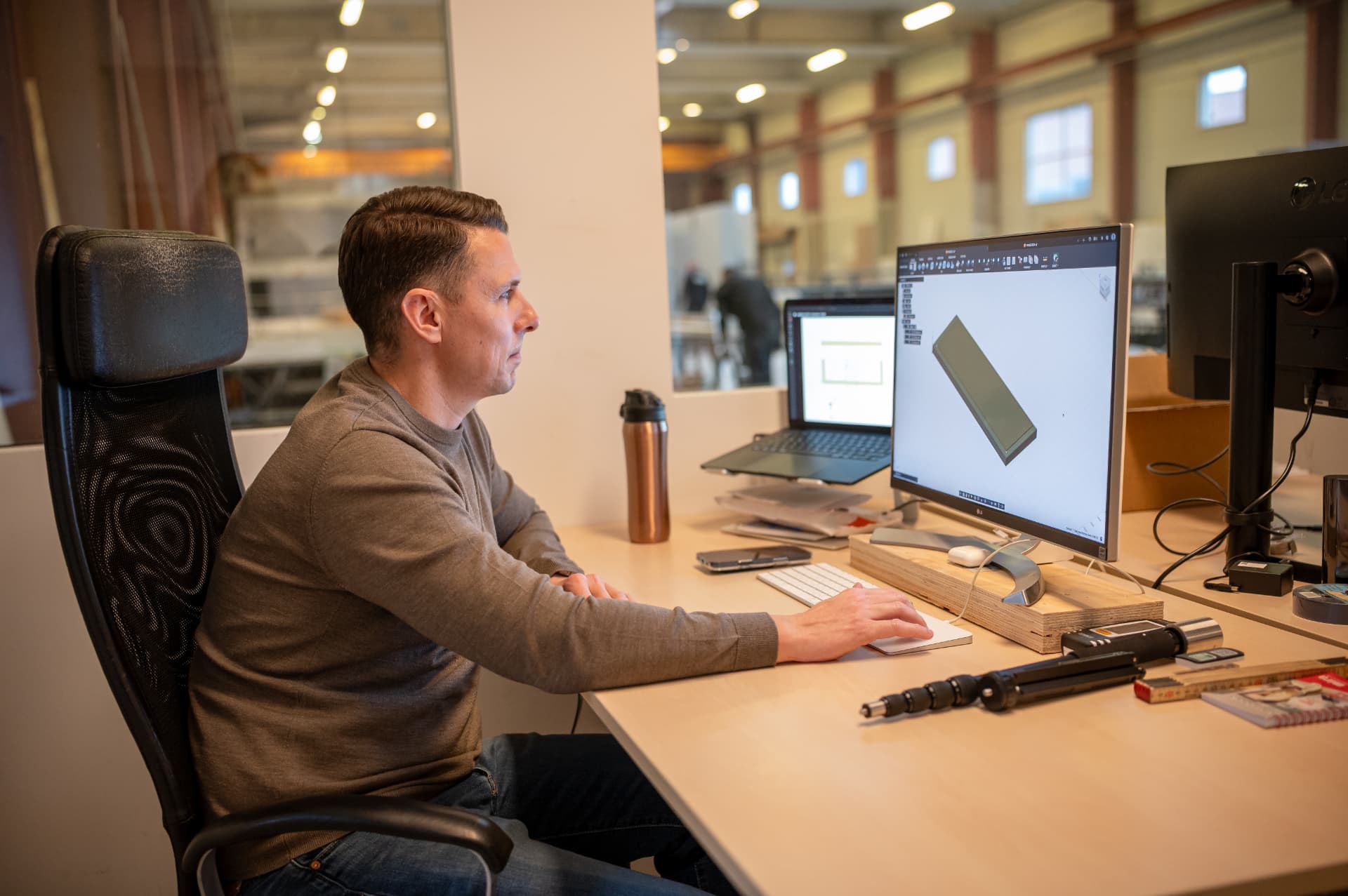 Medarbejder arbejder med 3D-model af et træelement på skærm på kontoret